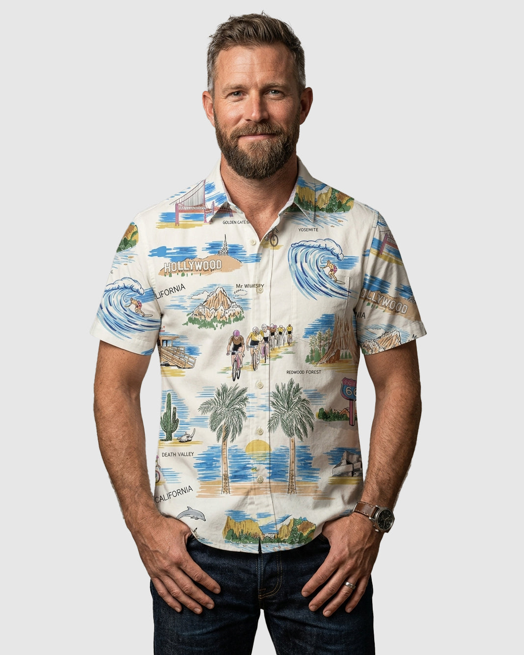 Man wearing a colorful patterned shirt with scenic design on a plain background